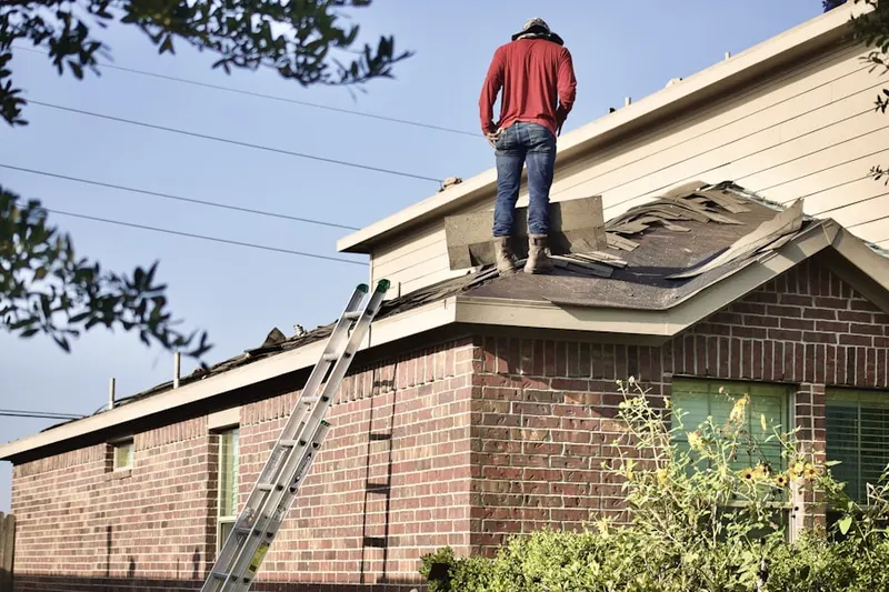 Professional roofer working on a residential roof in Fruitport